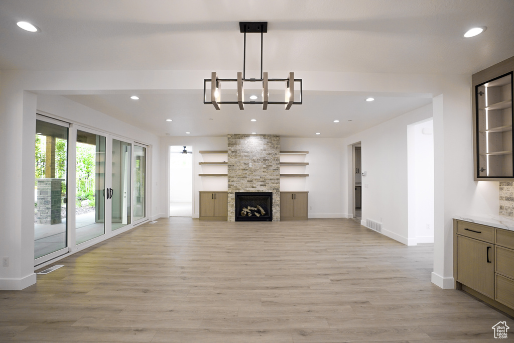 Unfurnished living room featuring light wood-type flooring, recessed lighting, and a fireplace