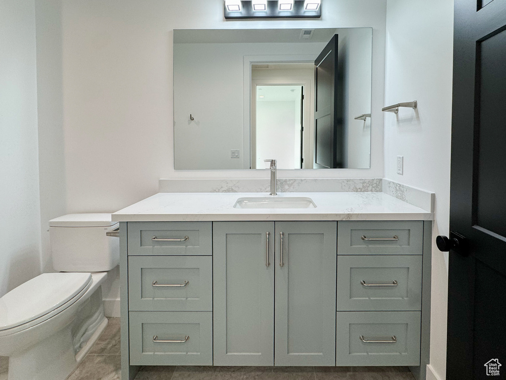 Half bathroom featuring vanity and toilet