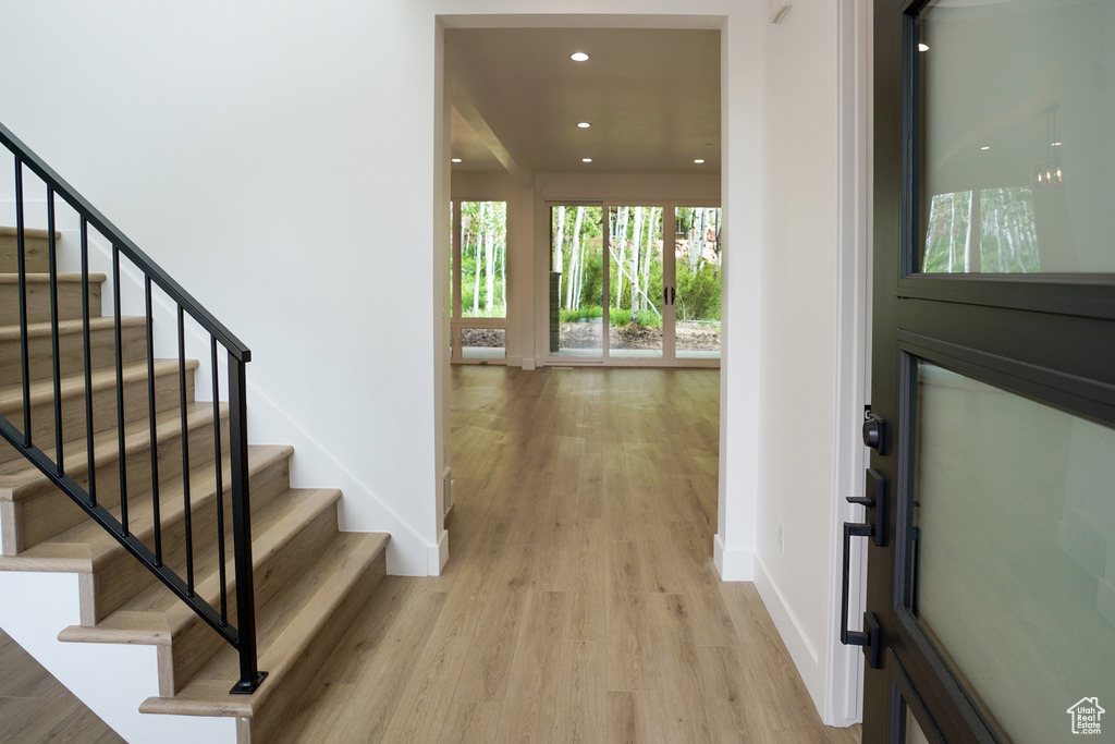 Entryway with light wood finished floors, stairs, and recessed lighting