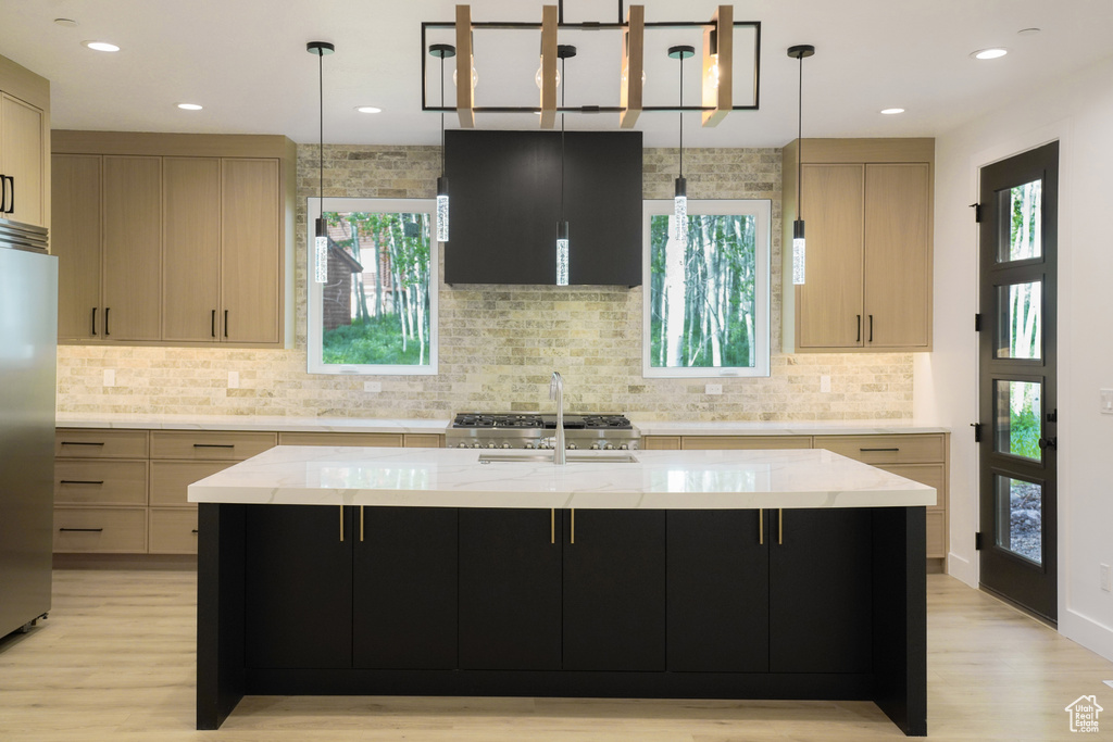Kitchen with range hood, stainless steel refrigerator, light wood finished floors, plenty of natural light, and recessed lighting