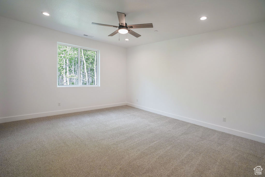 Carpeted spare room featuring a ceiling fan and recessed lighting