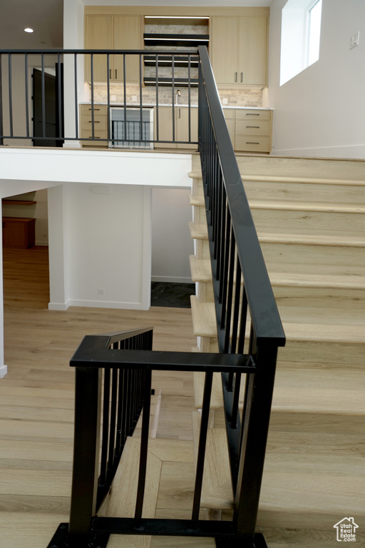 Staircase with baseboards and wood finished floors