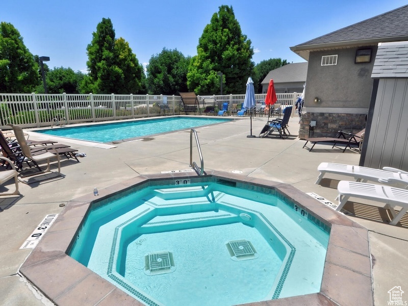Community pool featuring a community hot tub and a patio area