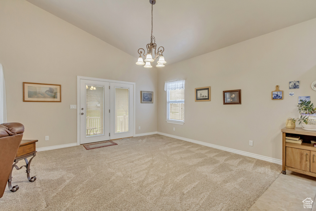 Office area with light colored carpet, a chandelier, and high vaulted ceiling