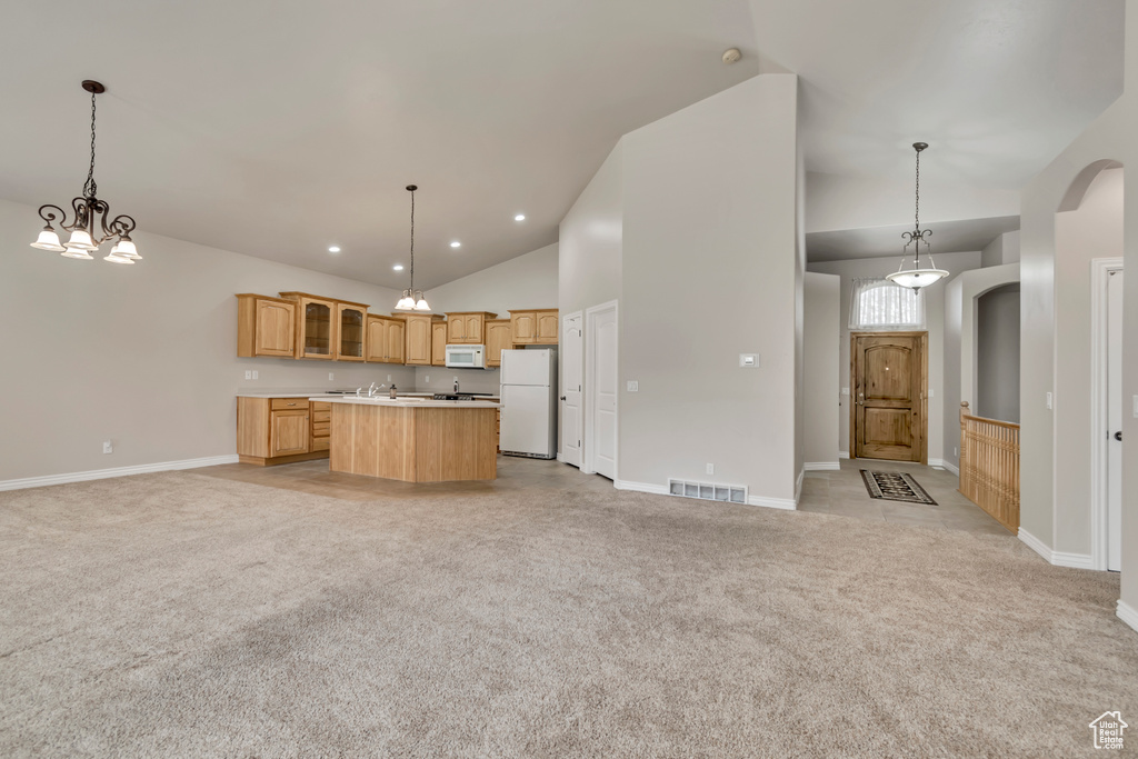 Kitchen with white appliances, open floor plan, light colored carpet, a center island, and glass insert cabinets