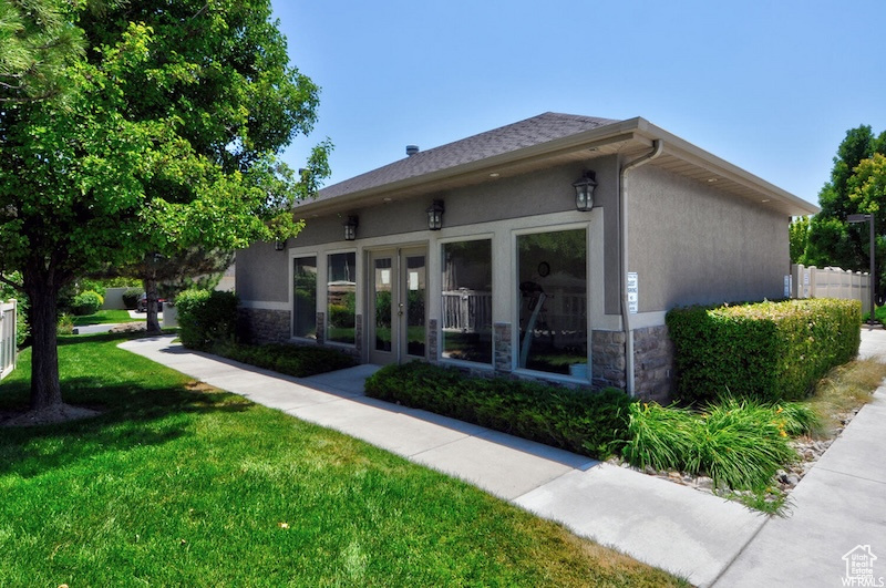 View of side of property with french doors, stone siding, and stucco siding