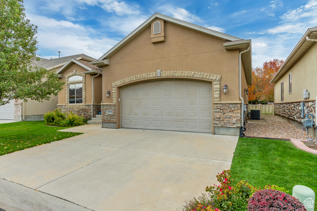 View of front of home featuring stone siding, stucco siding, driveway, and an attached garage