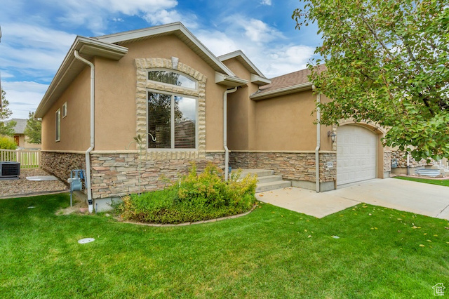 View of front facade featuring stone siding, stucco siding, driveway, an attached garage, and a front yard