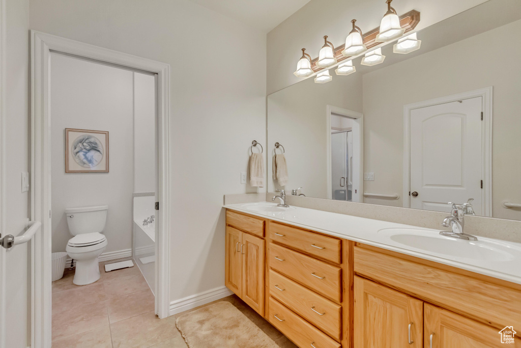 Full bath with double vanity, tile patterned floors, and a shower with door