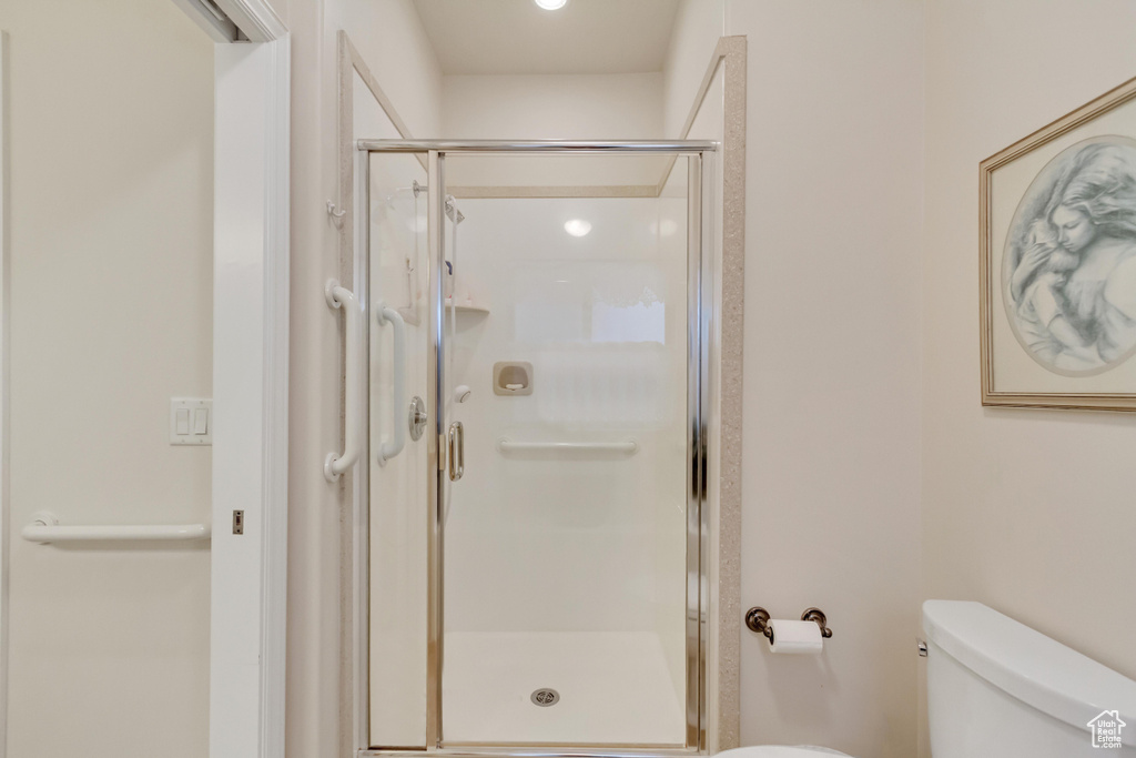 Full bathroom featuring toilet and a stall shower