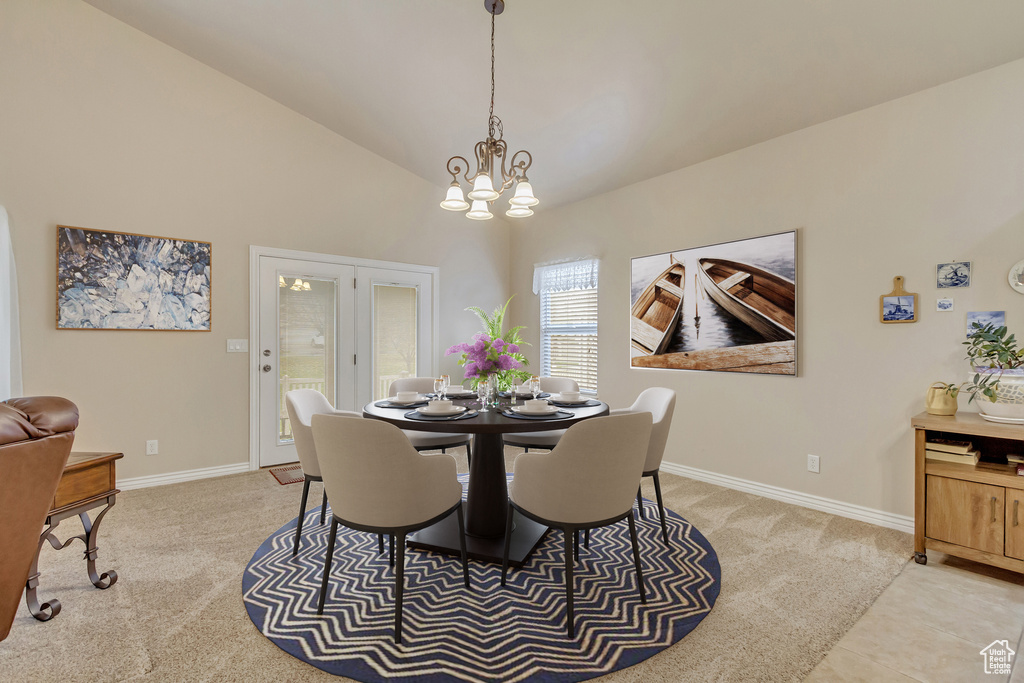 Dining room featuring light carpet, a chandelier, and high vaulted ceiling