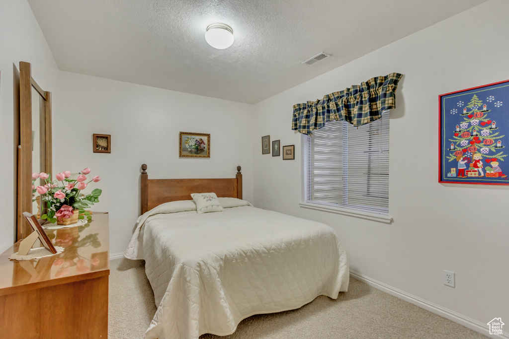 Bedroom with carpet and a textured ceiling