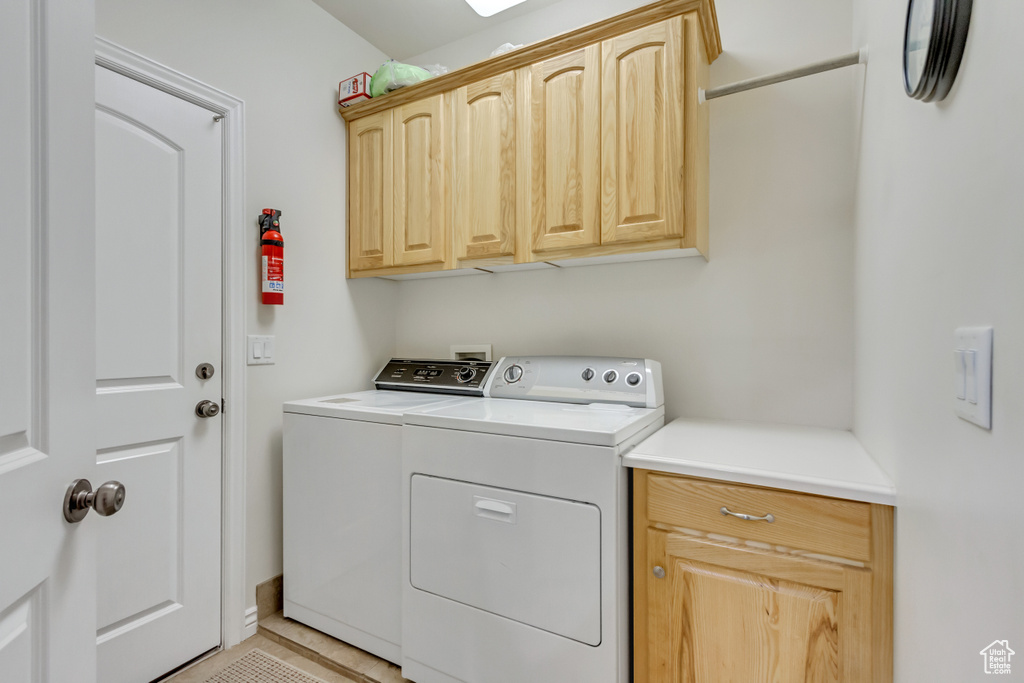 Washroom featuring cabinet space and independent washer and dryer