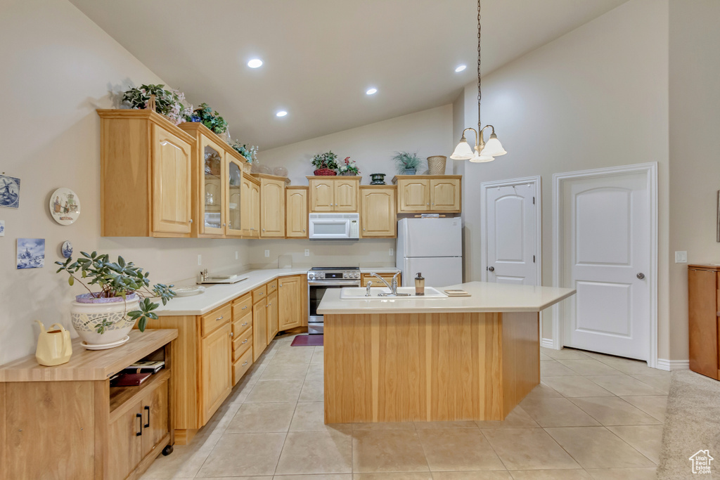 Kitchen featuring white appliances, high vaulted ceiling, light brown cabinets, a center island with sink, and recessed lighting