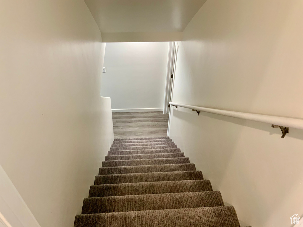 Stairs with wood finished floors and baseboards