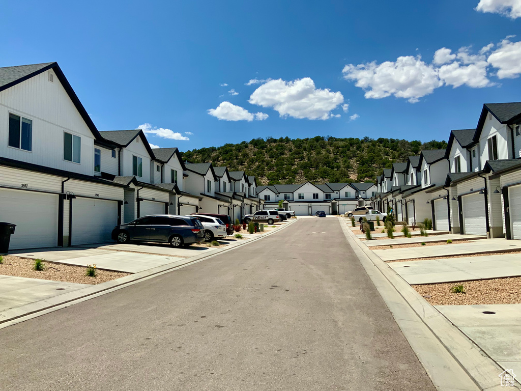View of asphalt road with a residential view and curbs