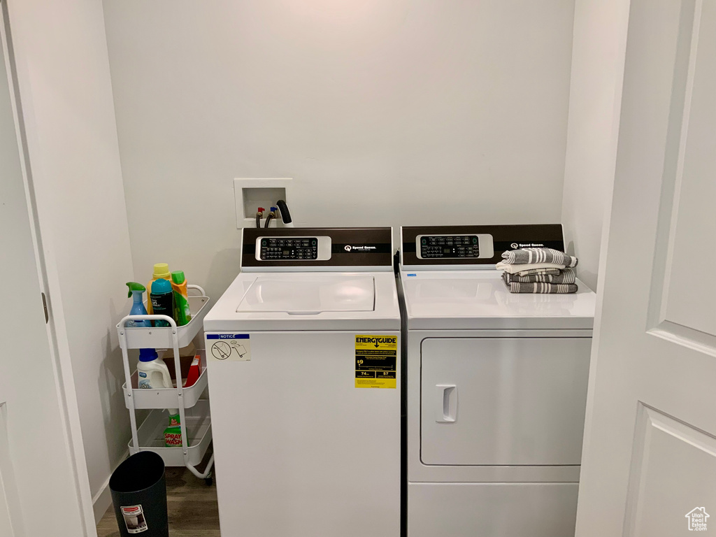 Laundry room with independent washer and dryer and wood finished floors