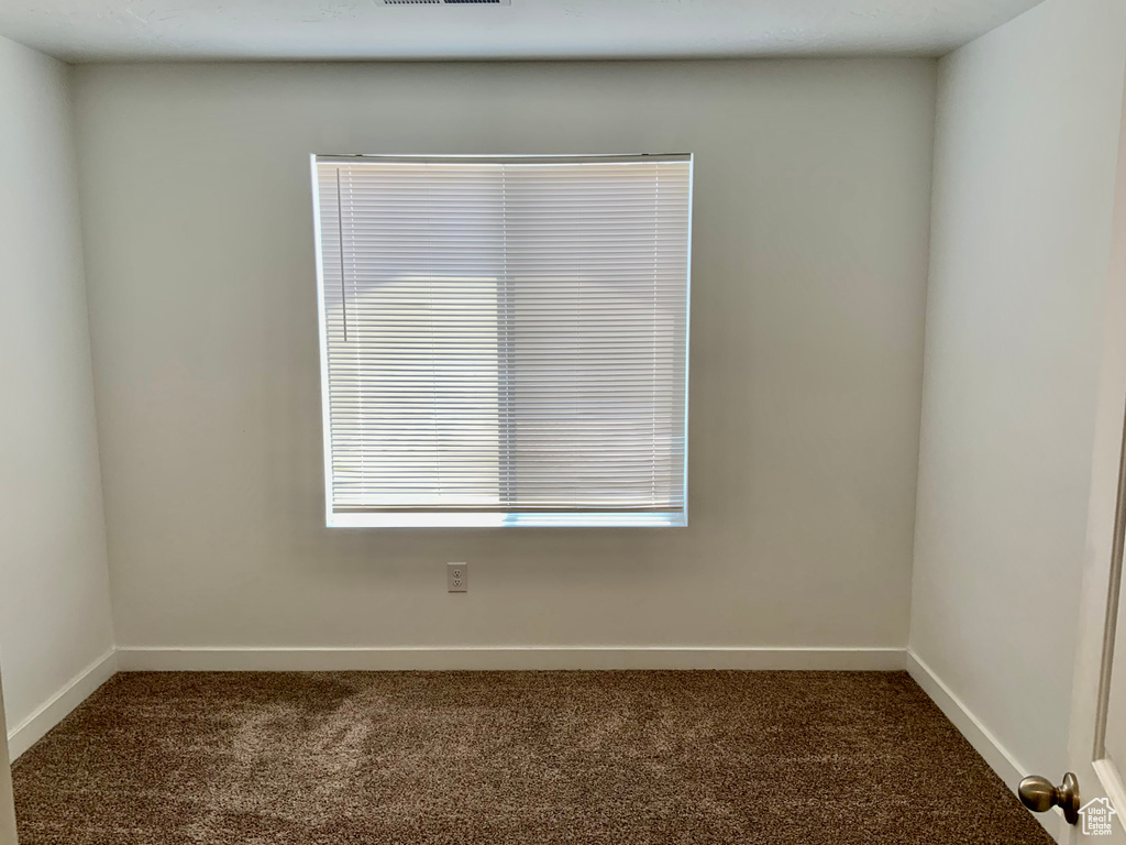 Carpeted empty room featuring healthy amount of natural light
