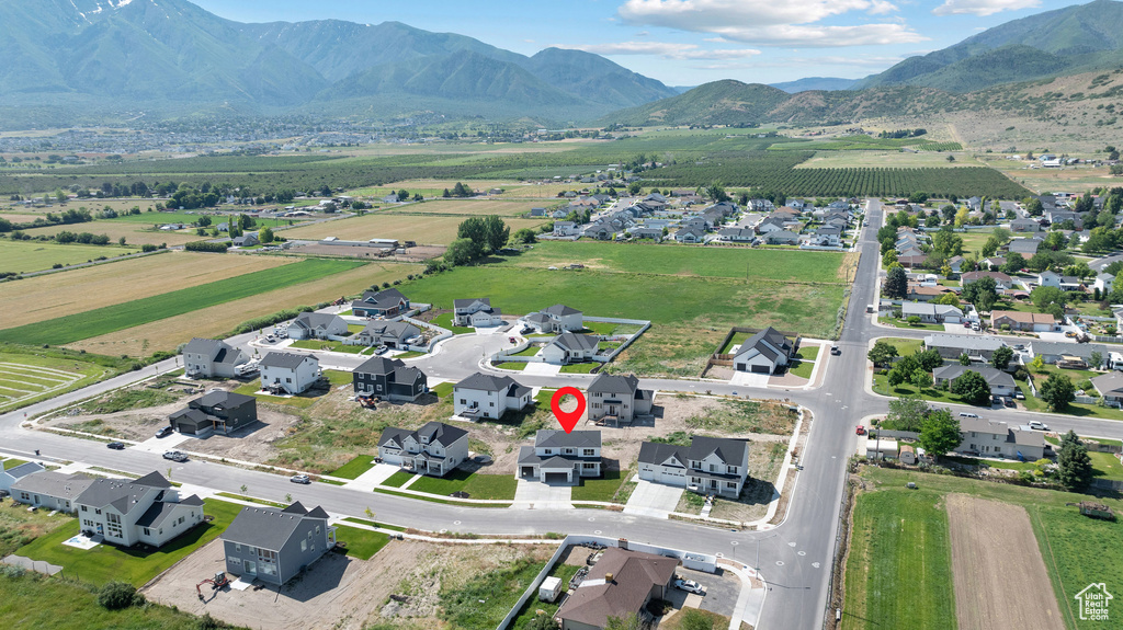 Aerial overview of property's location featuring a mountain backdrop, rural landscape, and nearby suburban area