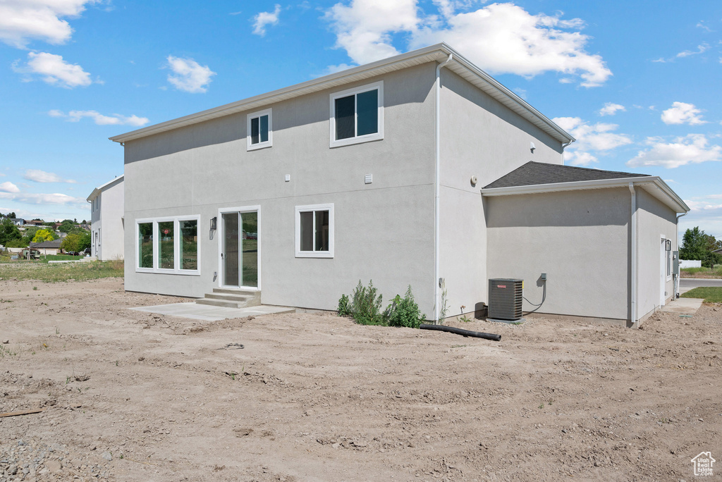 Back of house featuring entry steps and stucco siding