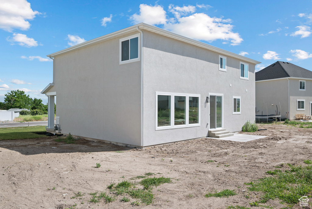 Back of property with entry steps and stucco siding