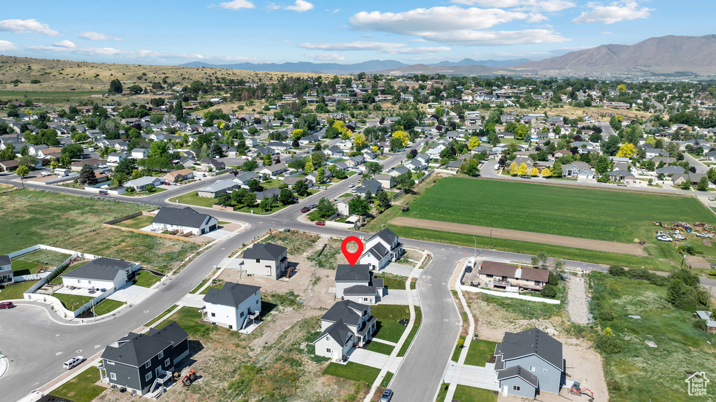 Aerial view of property and surrounding area with a mountain backdrop and nearby suburban area