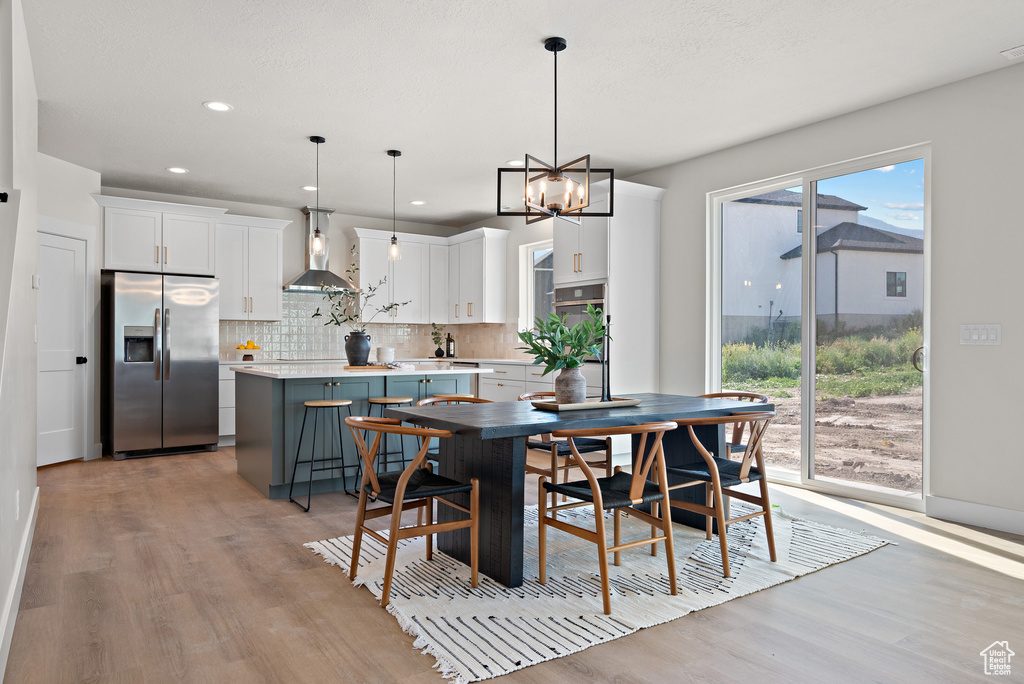 Dining room featuring light wood-style floors, a chandelier, and recessed lighting