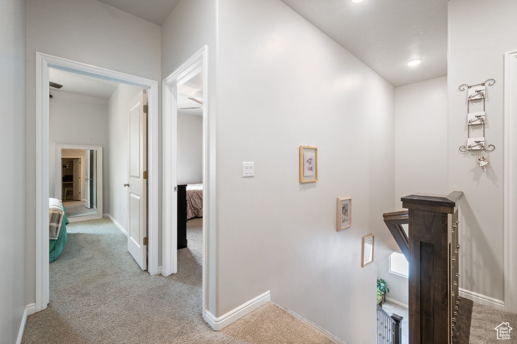 Hallway with carpet flooring and an upstairs landing