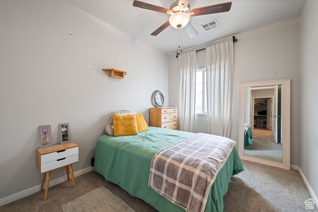 Carpeted bedroom featuring baseboards and ceiling fan
