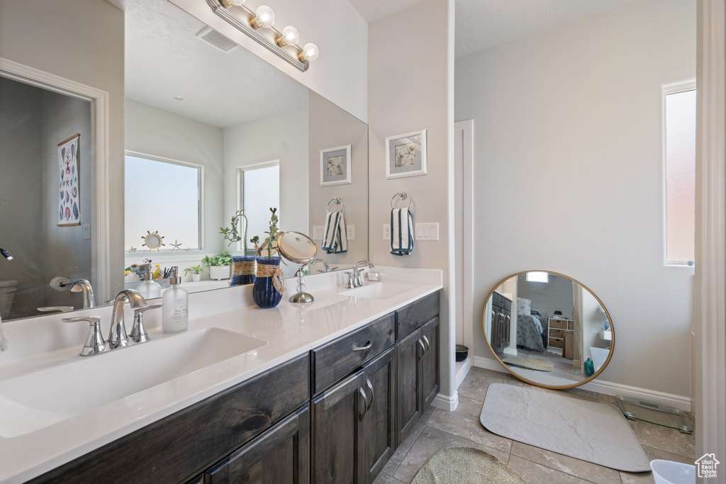 Full bath with double vanity and tile patterned floors