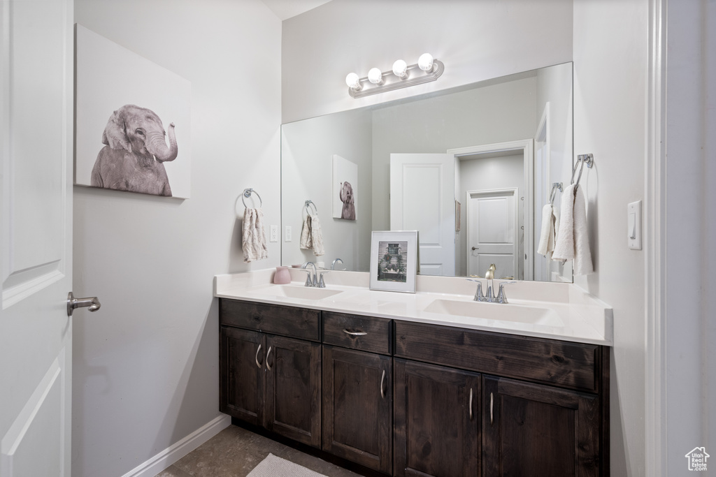 Bathroom featuring double vanity and baseboards