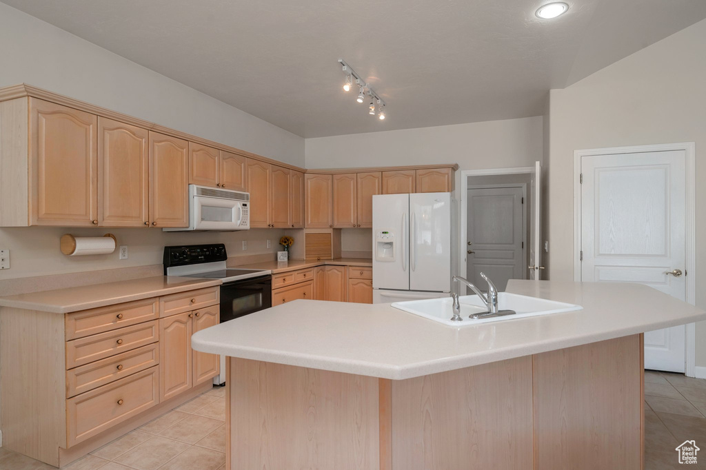 Kitchen with white appliances, light brown cabinets, light tile patterned floors, an island with sink, and light countertops