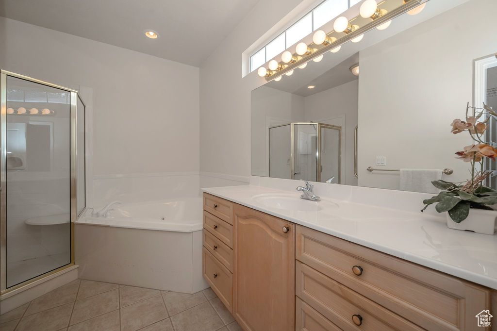 Bathroom with vanity, a stall shower, a garden tub, and tile patterned floors