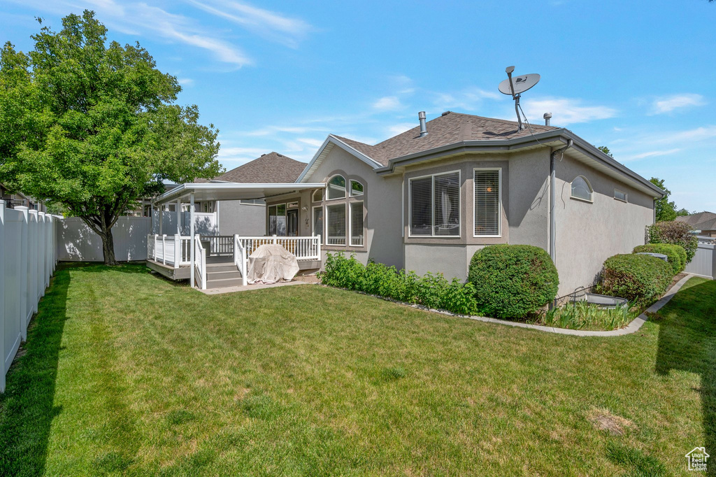 Back of property with stucco siding, a fenced backyard, and a shingled roof
