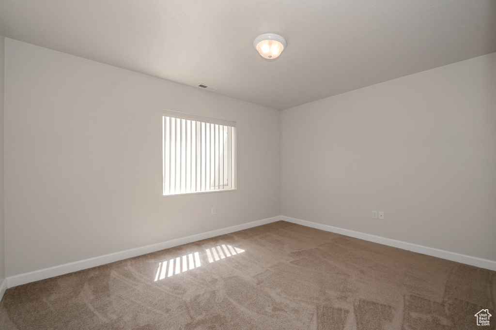 Unfurnished room featuring carpet floors and baseboards