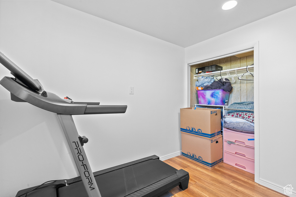 Workout area featuring light wood-style floors and recessed lighting