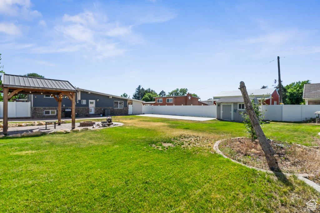 Fenced backyard with a fire pit and a shed