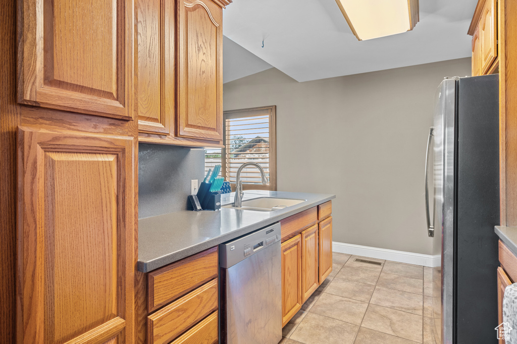 Kitchen featuring stainless steel appliances, light tile patterned floors, and light countertops