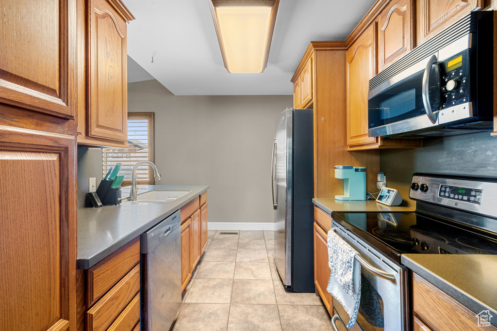 Kitchen featuring appliances with stainless steel finishes and light tile patterned flooring