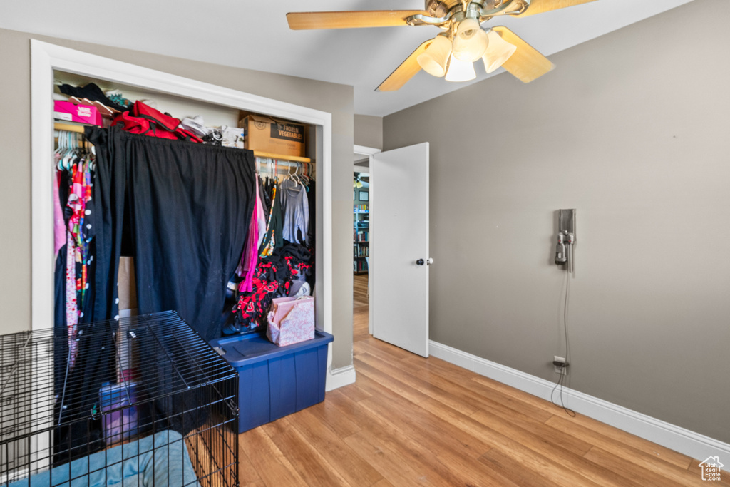 Bedroom with wood finished floors, a closet, and ceiling fan