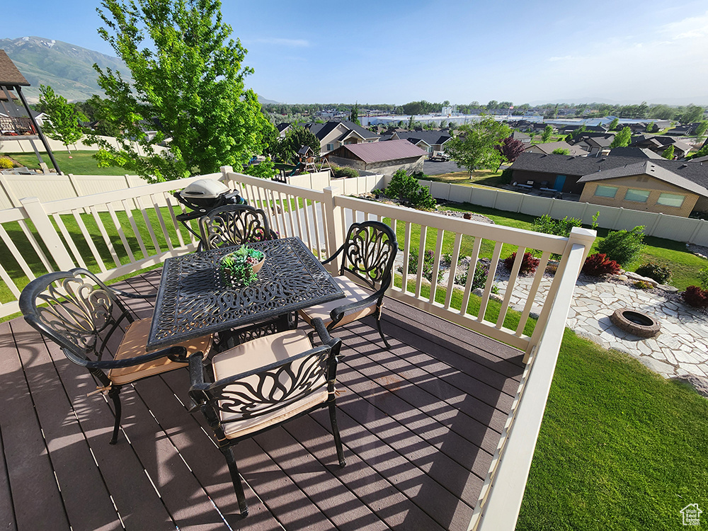 Wooden deck featuring an outdoor fire pit, a mountain view, and a residential view
