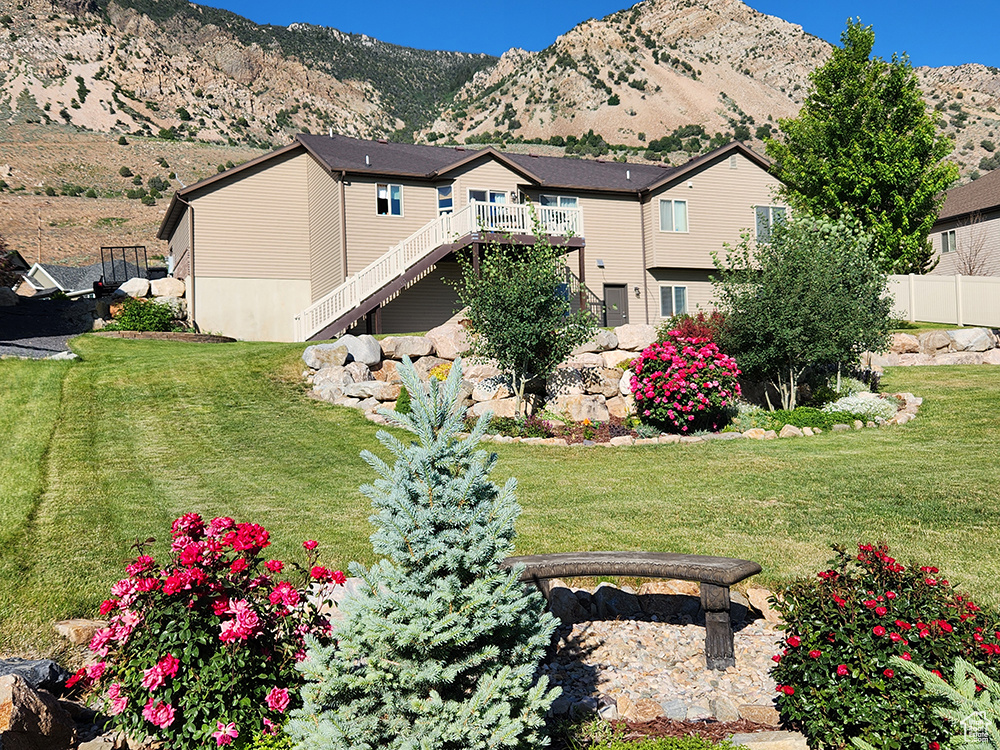 Rear view of house with a deck with mountain view and stairway
