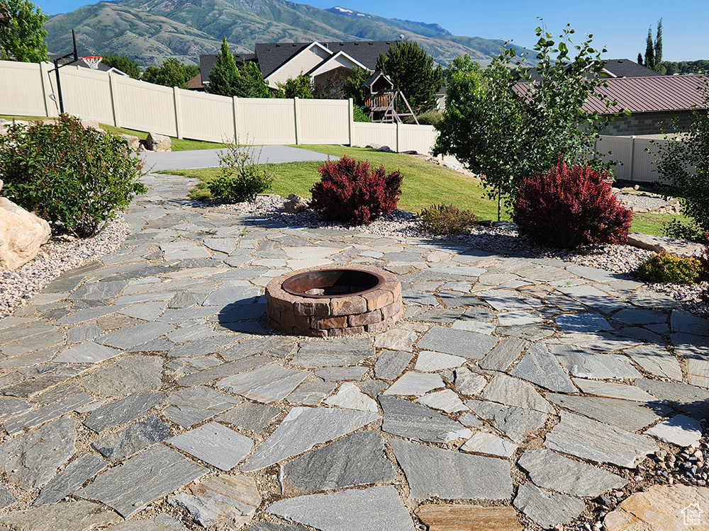 View of patio / terrace featuring an outdoor fire pit and a mountain view