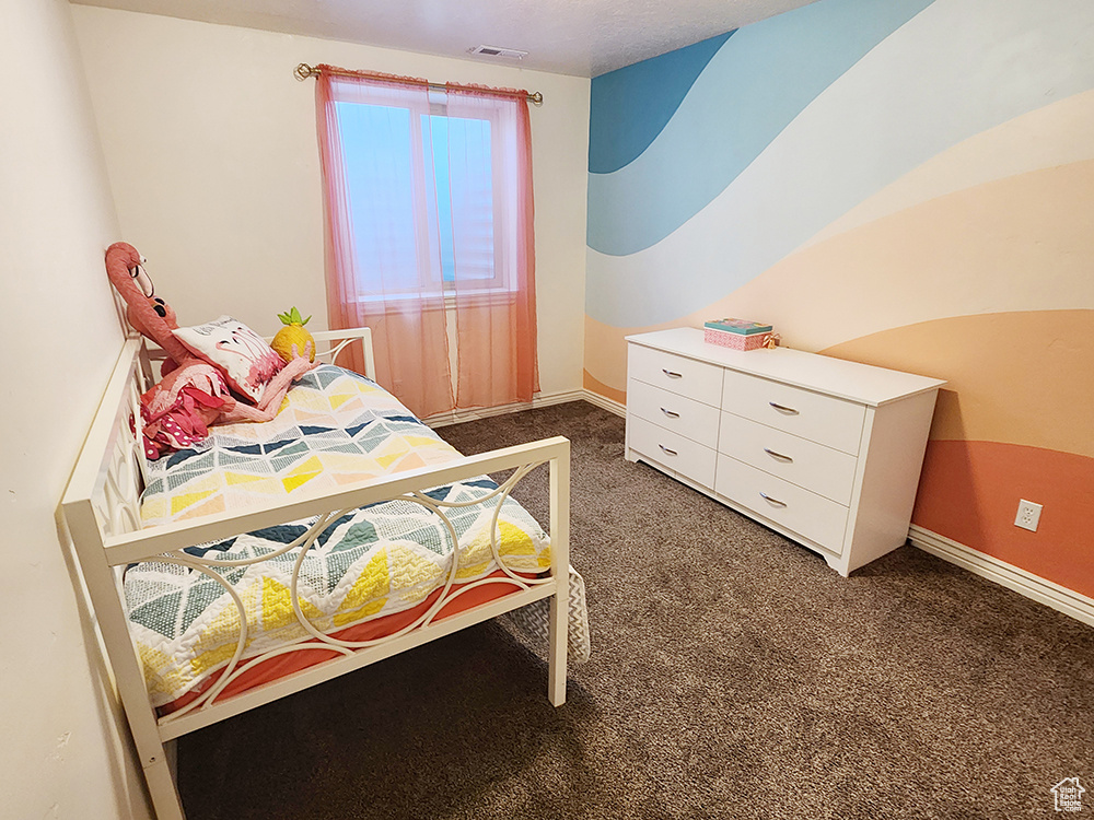 Bedroom featuring carpet flooring and baseboards