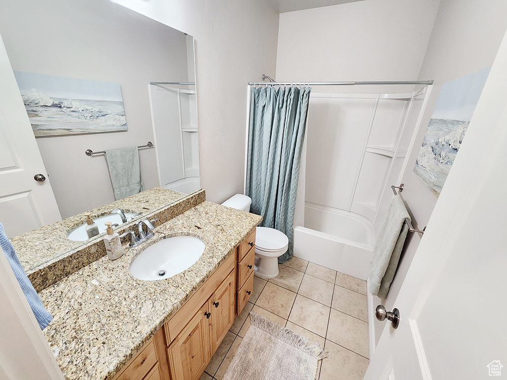 Bathroom featuring vanity, shower / bath combo with shower curtain, and tile patterned floors