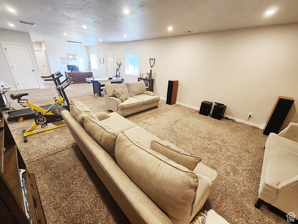 Living area with light carpet, recessed lighting, a textured ceiling, and billiards table