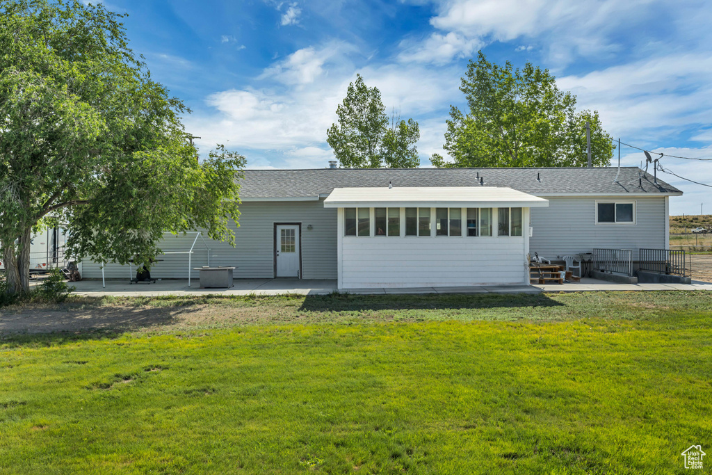 Back of house with a patio area and a yard