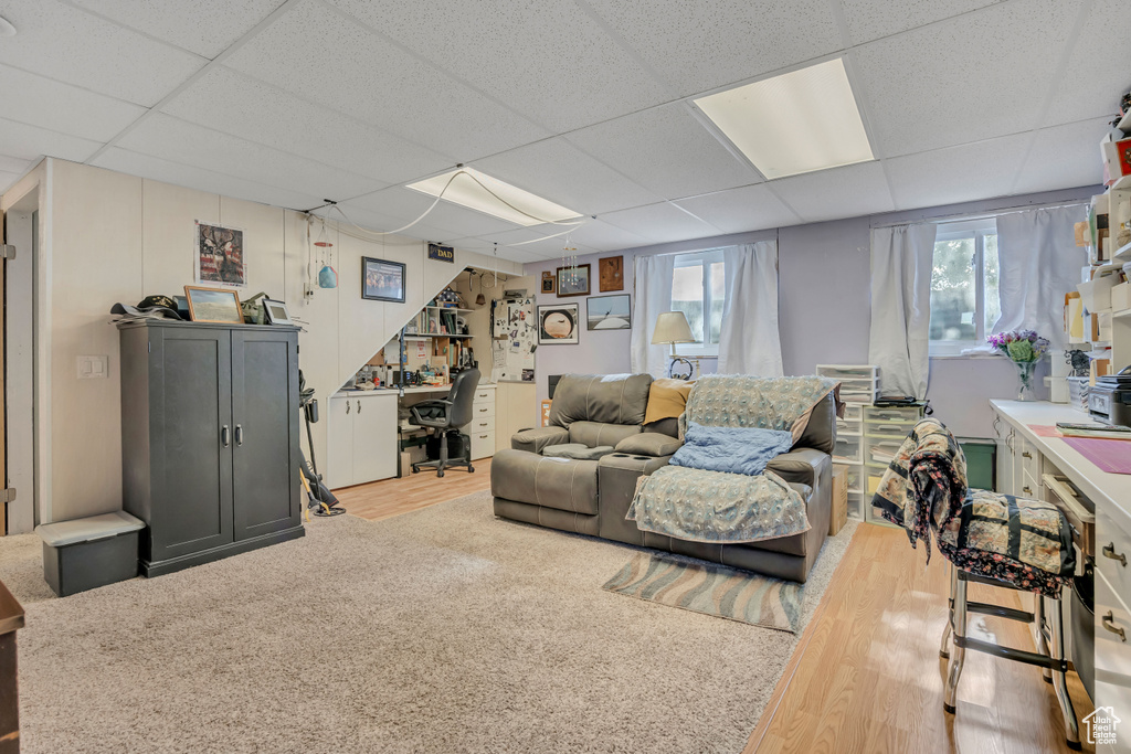 Living area featuring a paneled ceiling, an office area, and carpet floors