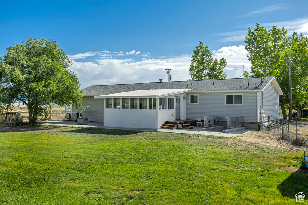 Back of property featuring entry steps, a patio, and a shingled roof