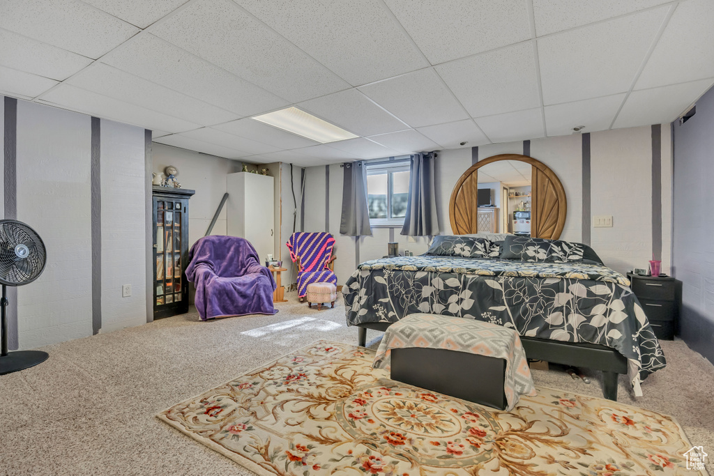 Bedroom with carpet flooring and a drop ceiling